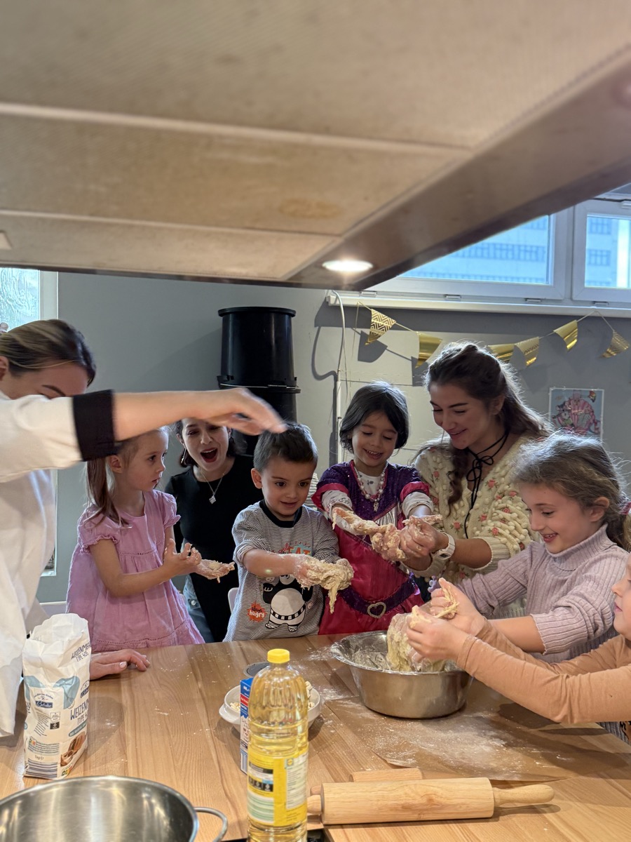 Kinder und Erwachsene beim gemeinsamen Backen